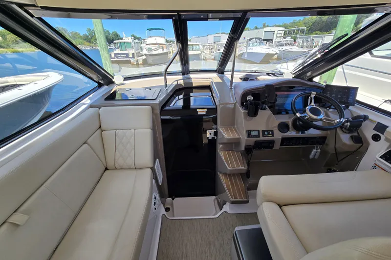  Yacht Photos Pics 2018 Regal 35 Sport Coupe interior with helm, steering wheel, and beige seating at marina.
