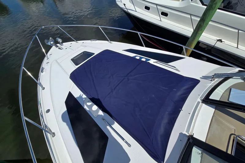  Yacht Photos Pics 2018 Regal 35 Sport Coupe boat with blue cover, docked at marina.
