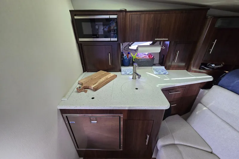  Yacht Photos Pics 2018 Regal 35 Sport Coupe interior kitchen with modern appliances and wooden cabinetry.