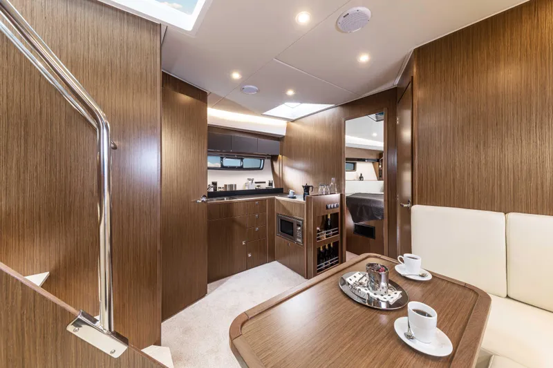 Inventory Clearance Yacht Photos Pics Luxurious interior of 2023 Bavaria SR41 COUPE yacht with modern kitchen and dining area.