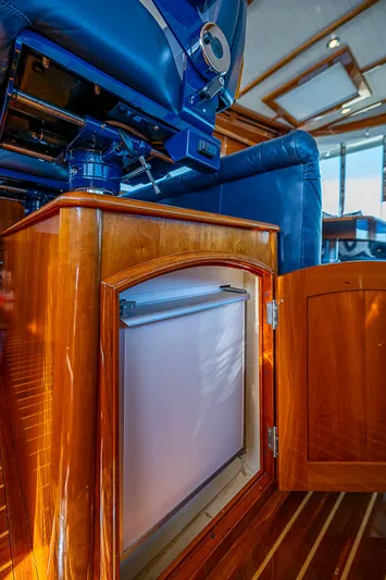 Hooligan VI Yacht Photos Pics Luxurious interior of 2005 Hinckley Talaria 55 MY yacht with wooden cabinetry and blue seating.