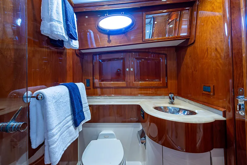 Hooligan VI Yacht Photos Pics Luxurious 2005 Hinckley Talaria 55 MY yacht bathroom with wood cabinetry and modern fixtures.