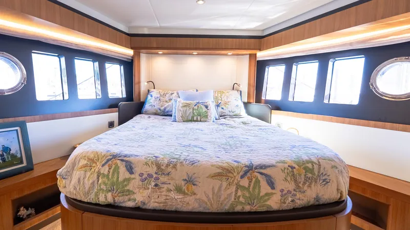Just Joanne Yacht Photos Pics Luxurious bedroom interior of 2019 Absolute NAVETTA 58 yacht with floral bedding and porthole windows.