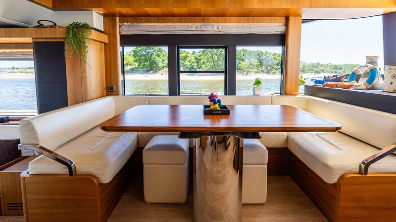 Just Joanne Yacht Photos Pics Luxurious interior of 2019 Absolute NAVETTA 58 yacht with elegant dining area and scenic window views.