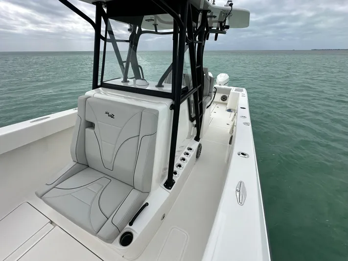  Yacht Photos Pics 2024 SeaVee 322z boat on calm ocean waters, showcasing sleek design and seating.