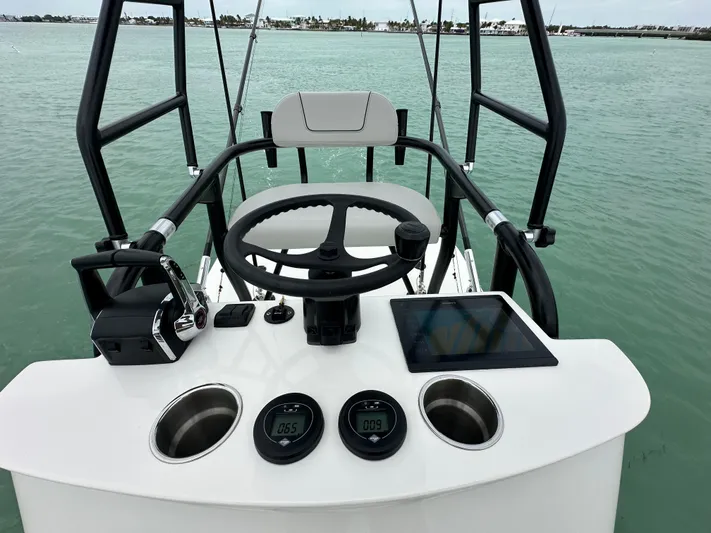  Yacht Photos Pics 2024 SeaVee 322z boat helm with steering wheel, controls, and digital displays on calm water.