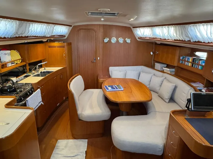  Yacht Photos Pics Luxurious interior of 2004 X-Yachts X 46 sailboat with cozy seating and kitchen area.