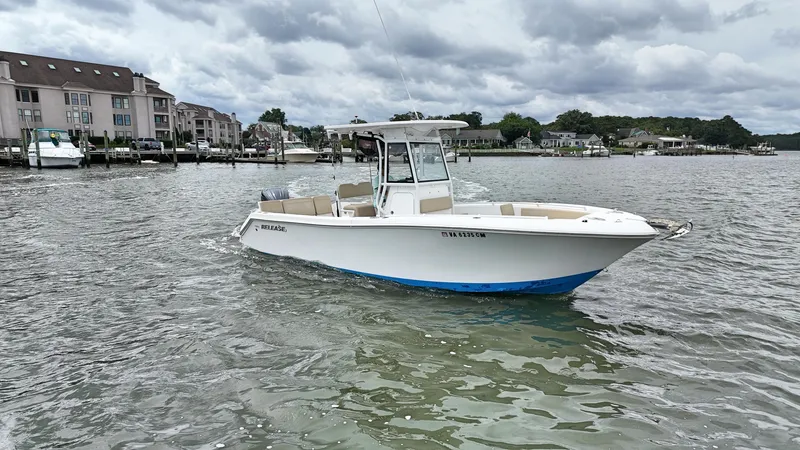  Yacht Photos Pics 2022 Release 240RX boat on water near residential docks under cloudy sky.