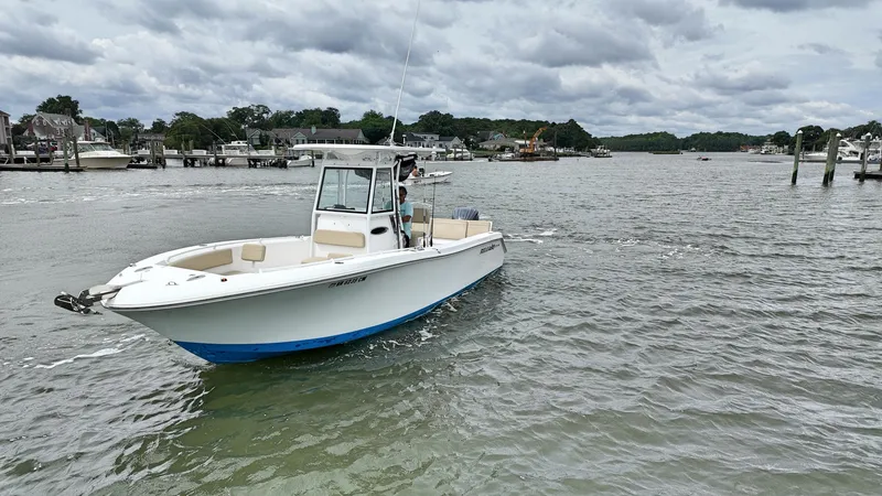  Yacht Photos Pics 2022 Release 240RX boat on a calm river with cloudy skies.