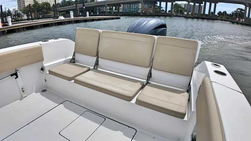  Yacht Photos Pics 2022 Release 240RX boat with beige seating, docked near a waterfront.