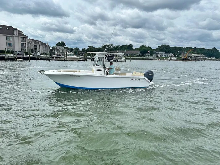  Yacht Photos Pics A 2022 Release 240RX boat cruising on a cloudy day near waterfront homes.