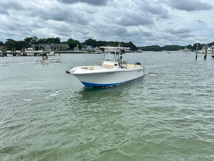  Yacht Photos Pics 2022 Release 240RX boat cruising on a calm river under cloudy skies.