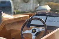 2024 Custom Bowrider dashboard with Garmin navigation and wooden steering wheel.
