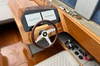 2024 Custom Bowrider dashboard with Garmin displays and wooden steering wheel.