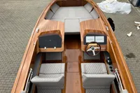 2024 Custom Bowrider boat with wooden interior and cushioned seating.