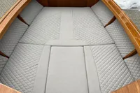 2024 Custom Bowrider boat interior with quilted gray seating and wooden accents.