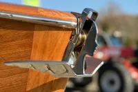 2024 Custom Bowrider with polished metal detail on wooden hull, showcasing craftsmanship.