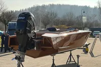 2024 Custom Bowrider boat with powerful outboard motor on display outdoors.