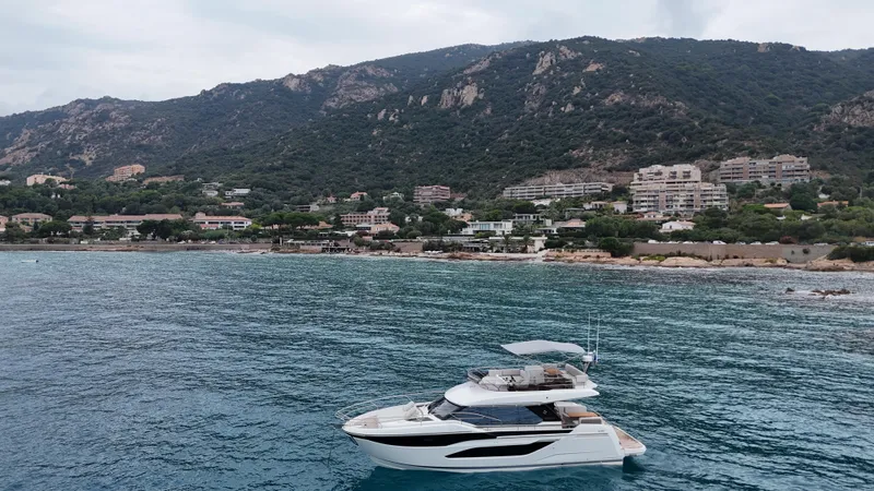 Prestige F4.9 Yacht Photos Pics Luxury Prestige F4 yacht cruising near scenic coastal landscape, 2025 model.