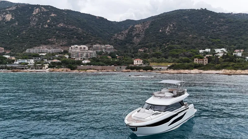 Prestige F4.9 Yacht Photos Pics Luxurious 2025 Prestige F4 yacht cruising near scenic coastal landscape.