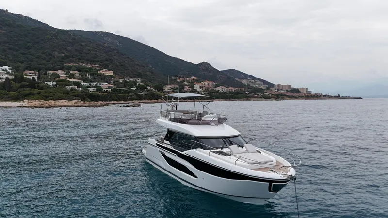 Prestige F4.9 Yacht Photos Pics Prestige F4 yacht 2025 model cruising near a scenic coastal landscape.