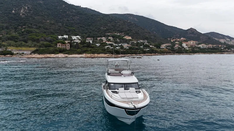 Prestige F4.9 Yacht Photos Pics Prestige F4 yacht (2025) on serene waters near a coastal landscape.