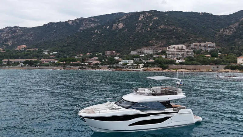 Prestige F4.9 Yacht Photos Pics Luxury 2025 Prestige F4 yacht cruising near scenic coastal mountains.