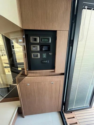 Prestige F4.9 Yacht Photos Pics Control panel inside 2025 Prestige F4 yacht, featuring modern wood cabinetry and sleek design.