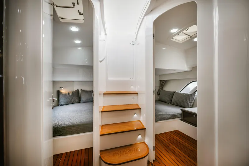  Yacht Photos Pics Luxurious interior of 2018 Intrepid 475 Sport Yacht with wooden steps and cozy cabins.