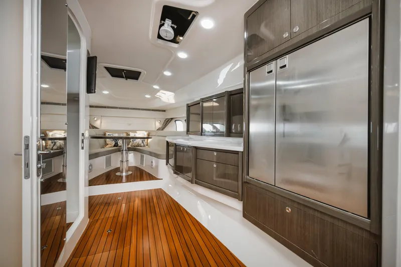 Yacht Photos Pics Luxurious interior of 2018 Intrepid 475 Sport Yacht with sleek cabinetry and wood flooring.