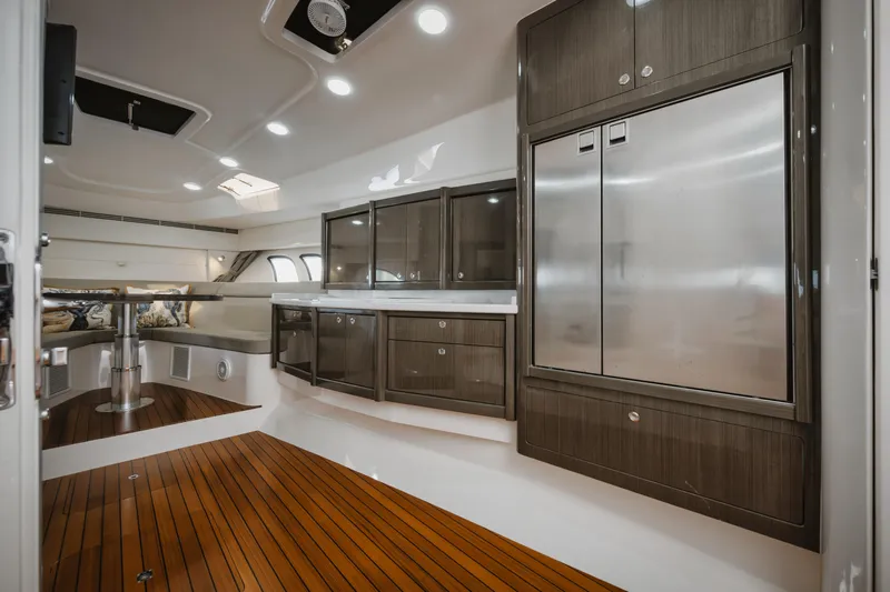  Yacht Photos Pics Luxurious interior of 2018 Intrepid 475 Sport Yacht with sleek cabinetry and wooden flooring.