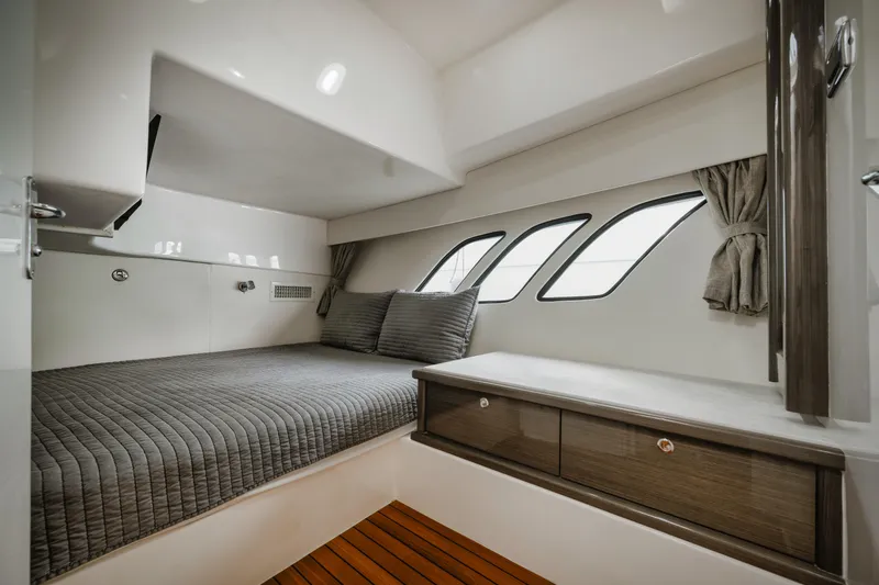  Yacht Photos Pics 2018 Intrepid 475 Sport Yacht cabin with bed, windows, and wooden flooring.