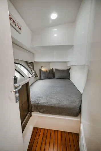  Yacht Photos Pics Cozy cabin interior of 2018 Intrepid 475 Sport Yacht with wood flooring and modern bedding.