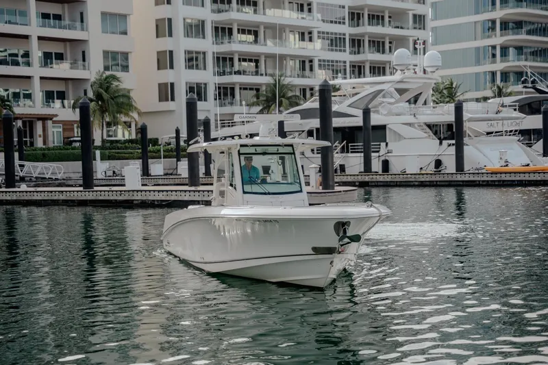  Yacht Photos Pics 2014 Boston Whaler 350 Outrage boat docked in a marina with modern buildings.