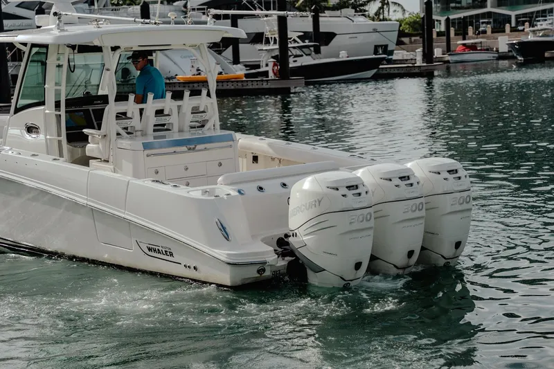  Yacht Photos Pics 2014 Boston Whaler 350 Outrage with triple Mercury engines in a marina setting.
