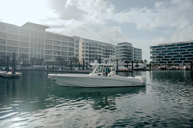  Yacht Photos Pics 2014 Boston Whaler 350 Outrage in marina, modern buildings in background.