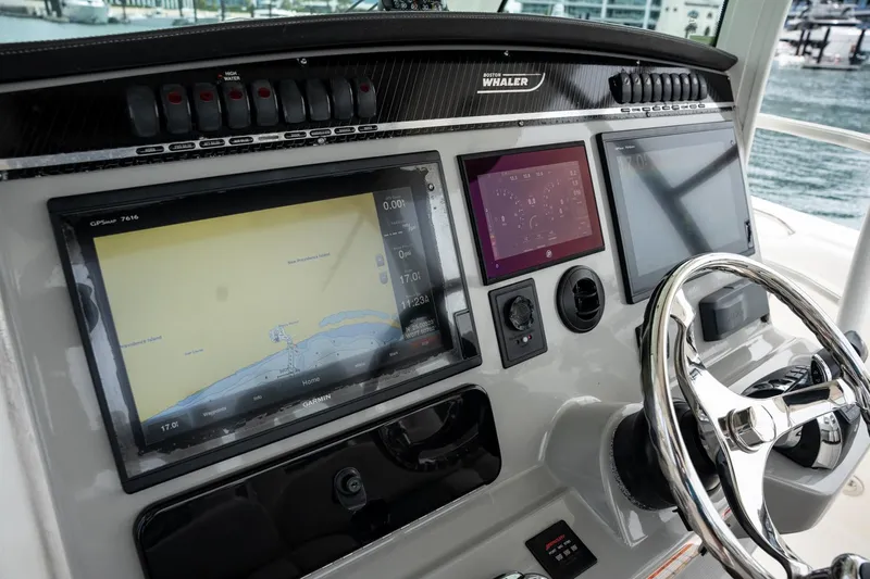  Yacht Photos Pics Boston Whaler 350 Outrage 2014 helm with navigation screens and steering wheel.