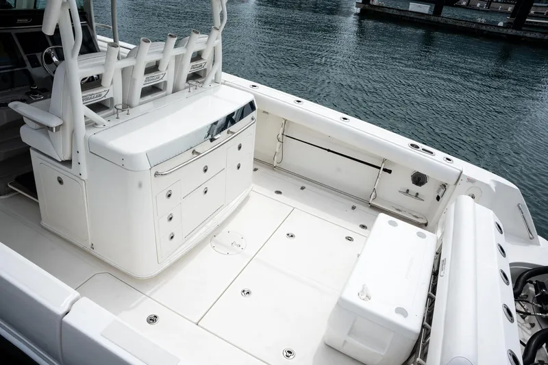  Yacht Photos Pics 2014 Boston Whaler 350 Outrage boat interior with seating and storage, docked by the water.