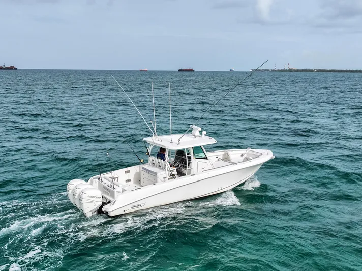  Yacht Photos Pics 2014 Boston Whaler 350 Outrage cruising on open sea with fishing rods.