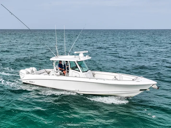  Yacht Photos Pics 2014 Boston Whaler 350 Outrage cruising on open sea with fishing rods.
