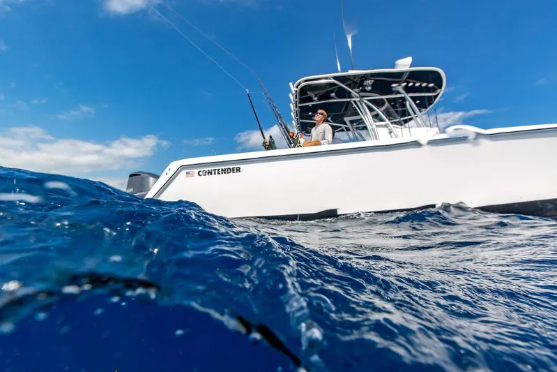  Yacht Photos Pics 2025 Contender 32 ST boat on the ocean with a person fishing.