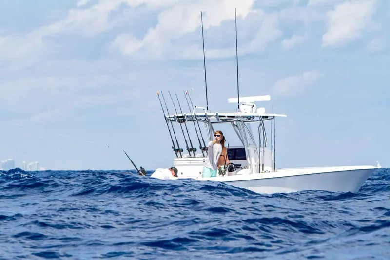  Yacht Photos Pics 2025 Contender 32 ST fishing boat on the ocean with a person fishing.