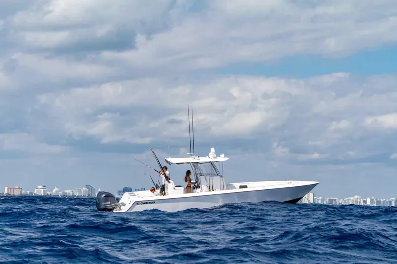  Yacht Photos Pics 2025 Contender 32 ST boat on open ocean with city skyline in background.