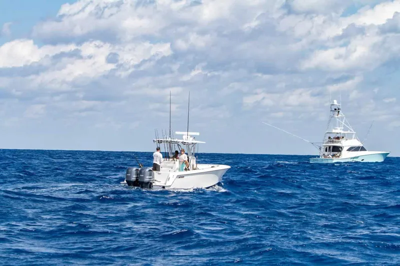  Yacht Photos Pics 2025 Contender 32 ST boat on open ocean with another boat in the background.