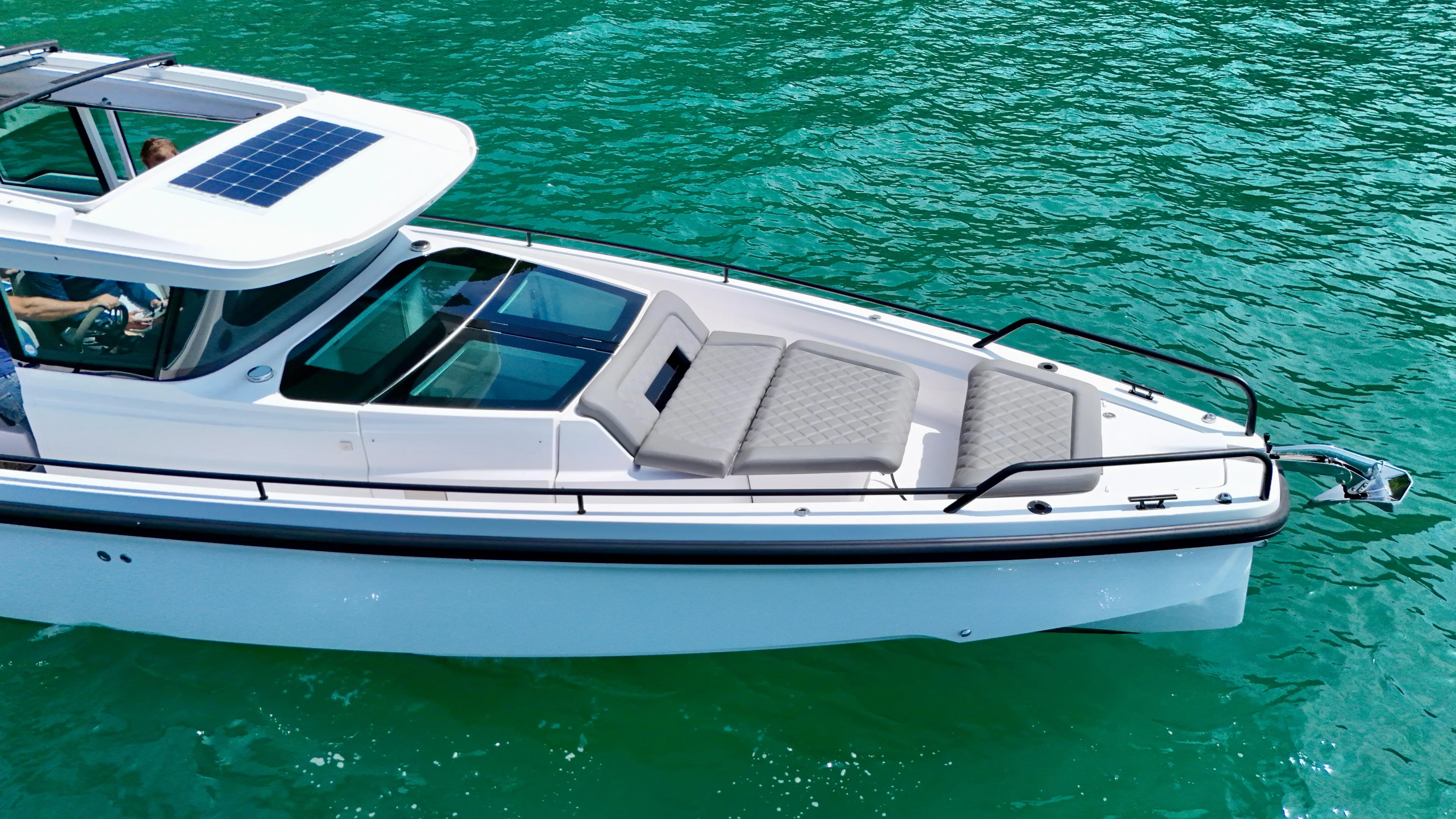 2020 Axopar 37 Cross Cabin boat on turquoise water, featuring solar panel and seating.