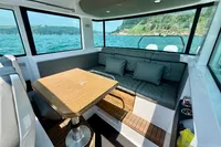 Interior of 2020 Axopar 37 Cross Cabin with seating and table, overlooking scenic water view.