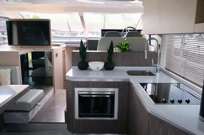  Yacht Photos Pics Luxurious interior of 2022 Sessa Marine Coupe 47 yacht with modern kitchen and seating area.