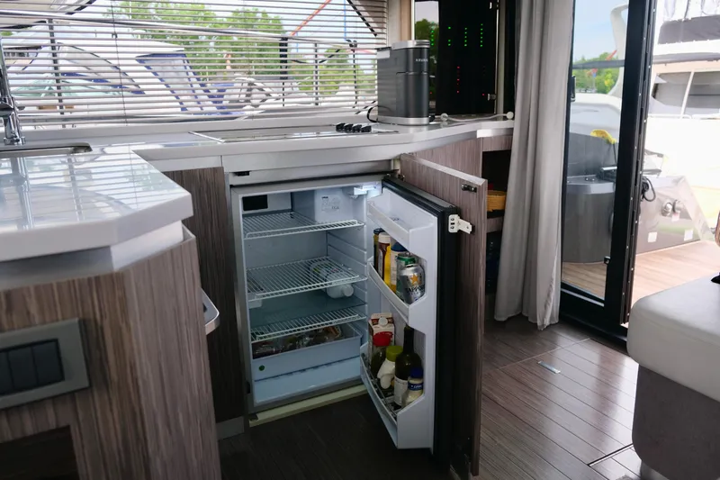  Yacht Photos Pics Modern kitchen interior of 2022 Sessa Marine Coupe 47 yacht with open fridge.