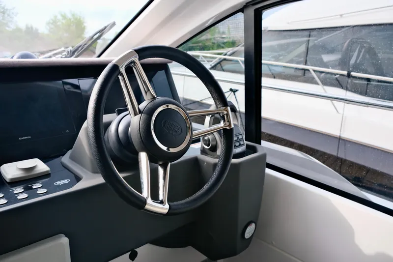  Yacht Photos Pics Steering wheel of 2022 Sessa Marine Coupe 47 yacht, featuring modern dashboard controls.