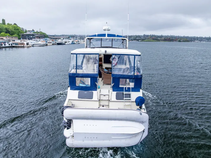 Bleu Fish Yacht Photos Pics 1988 Tollycraft 44 CPMY cruising on a calm lake with overcast skies.
